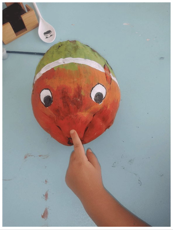 A child is pointing to Fun with Plants on a table.