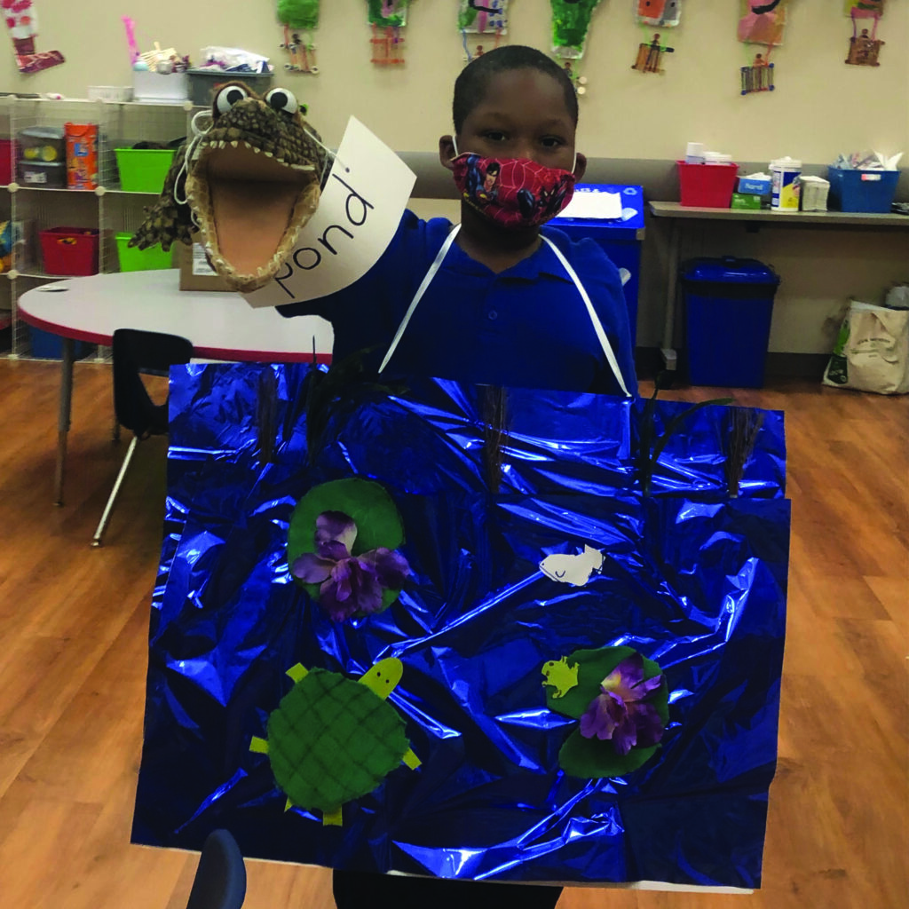 A boy wearing a mask and holding a piece of paper.