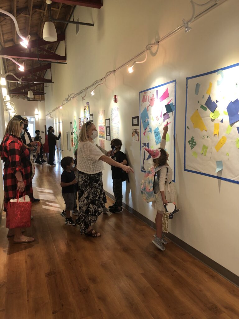 A group of student art enthusiasts looking at art in an art gallery.