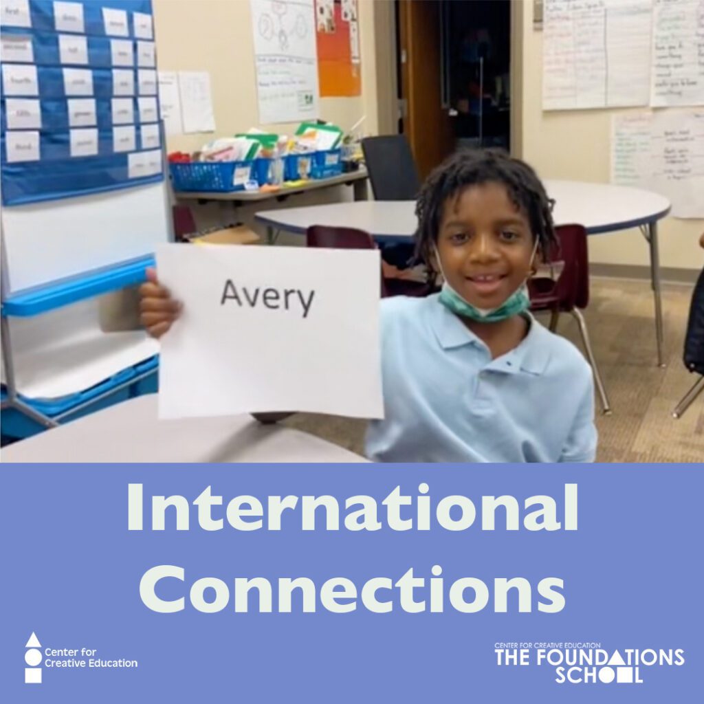 A young boy holding up a sign that says international art-i-facts connections.