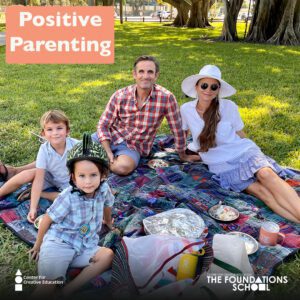 A family practices positive parenting while sitting on a blanket in the park, fostering healthy child behaviors.