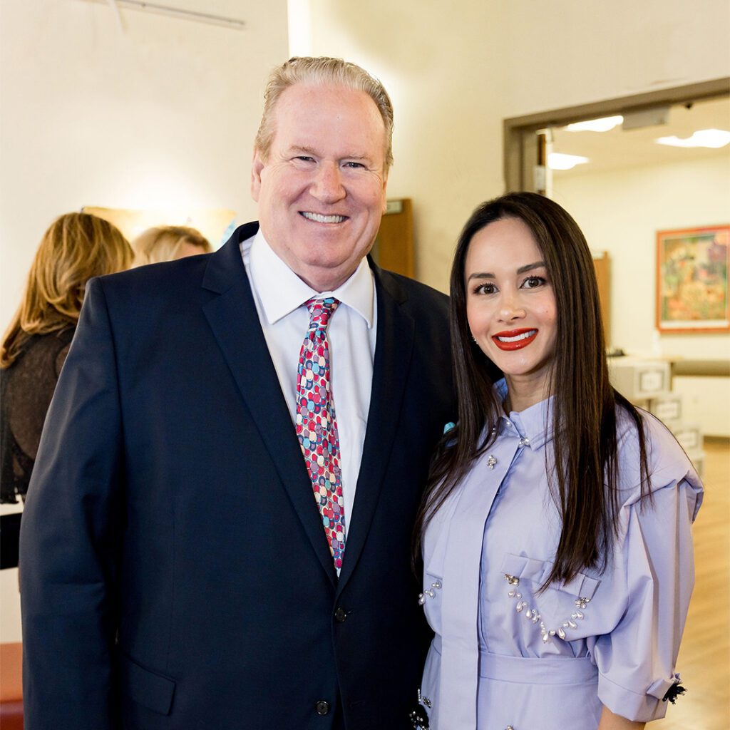 A man dressed in a suit standing next to a woman.