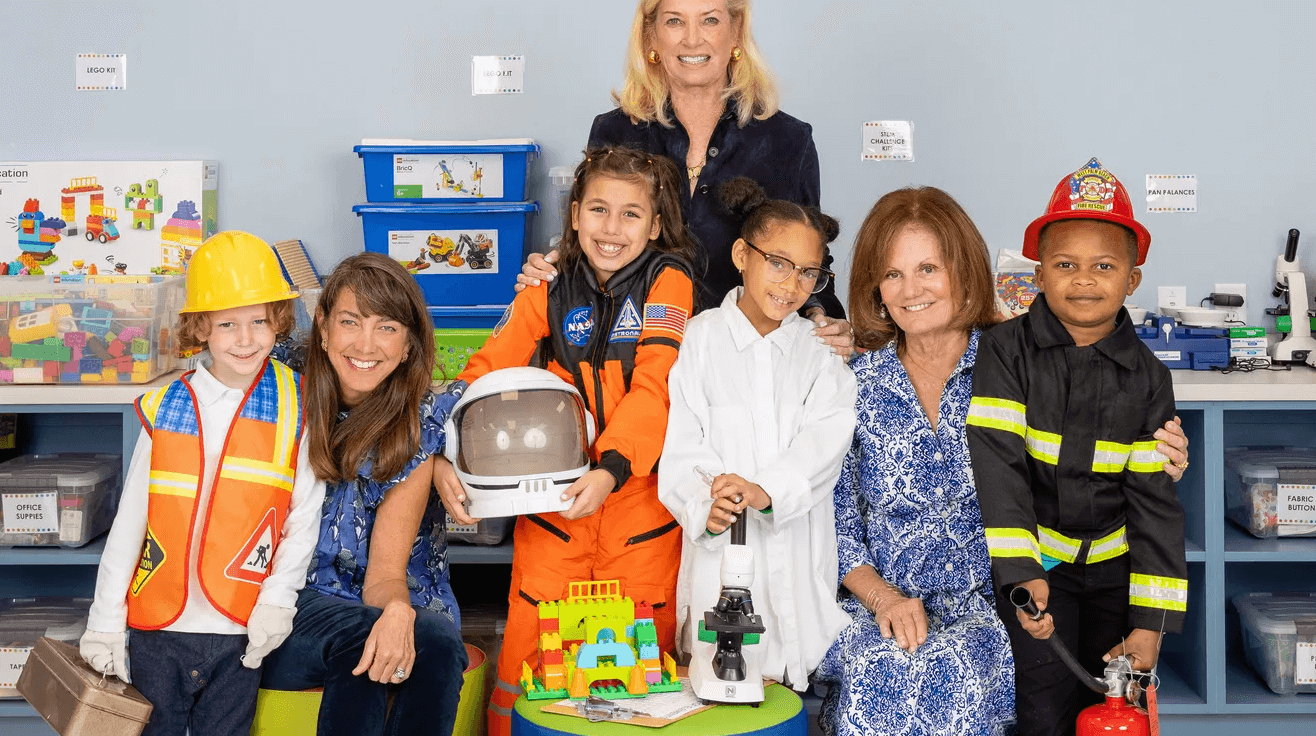 A group of children posing for a photo in a classroom, receiving a special message from the president.