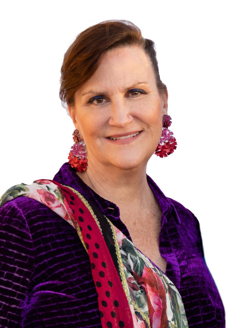 A woman wearing a purple shirt and a colorful scarf, giving thanks.