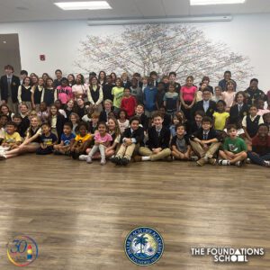 A group of children posing for a photo in a classroom, building school connections.