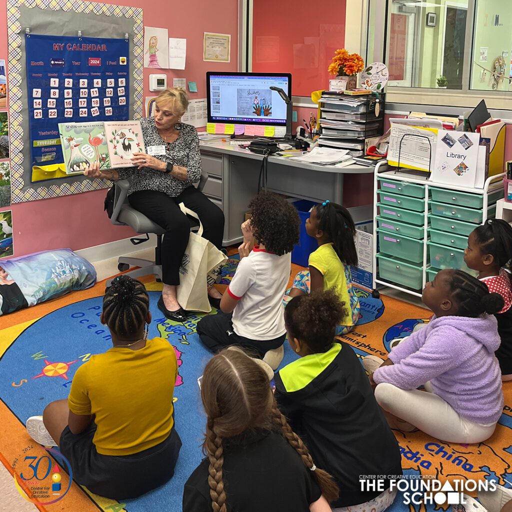 VIP Reader Etonella Christlieb reads a picture book to the second grade class seated on the carpet. 