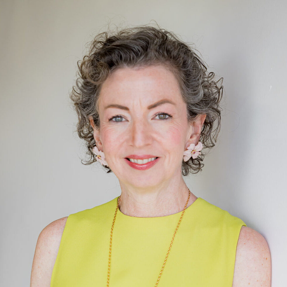 Woman smiling in a yellow dress.