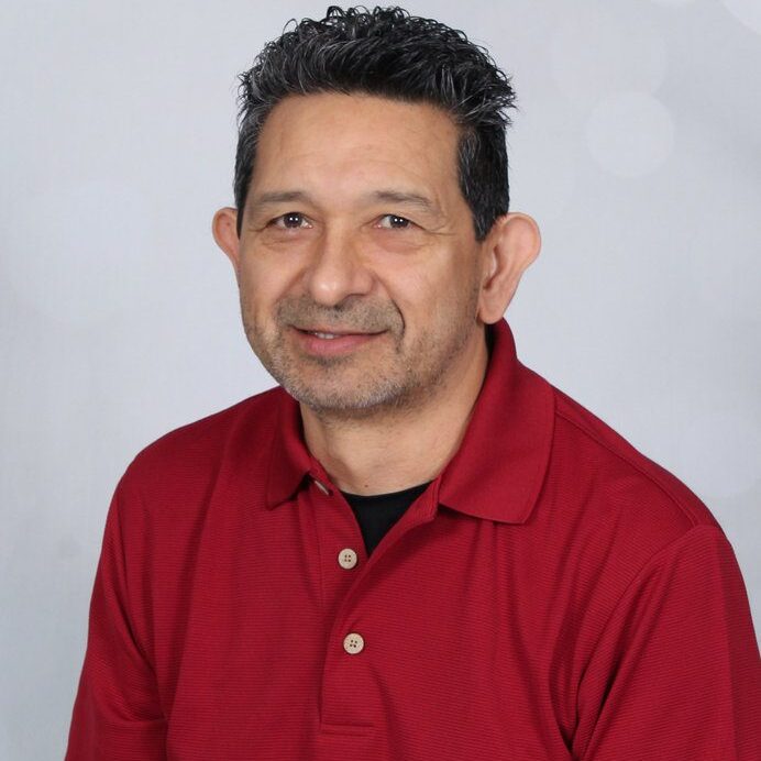 Man in red polo shirt smiling at camera.