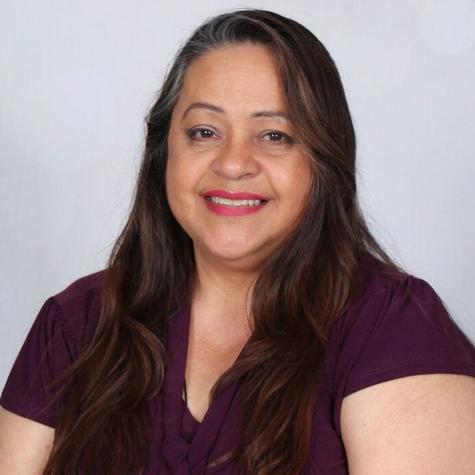 Woman smiling in a purple shirt.