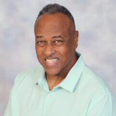 Smiling man in a light green shirt.