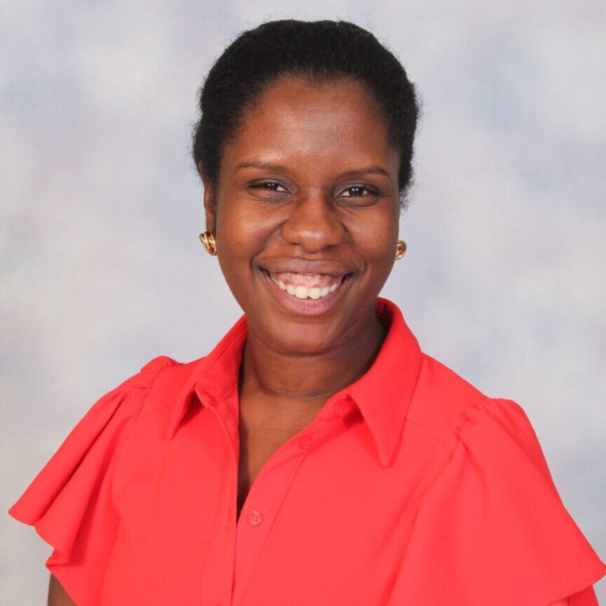 Smiling woman wearing a red collared shirt.