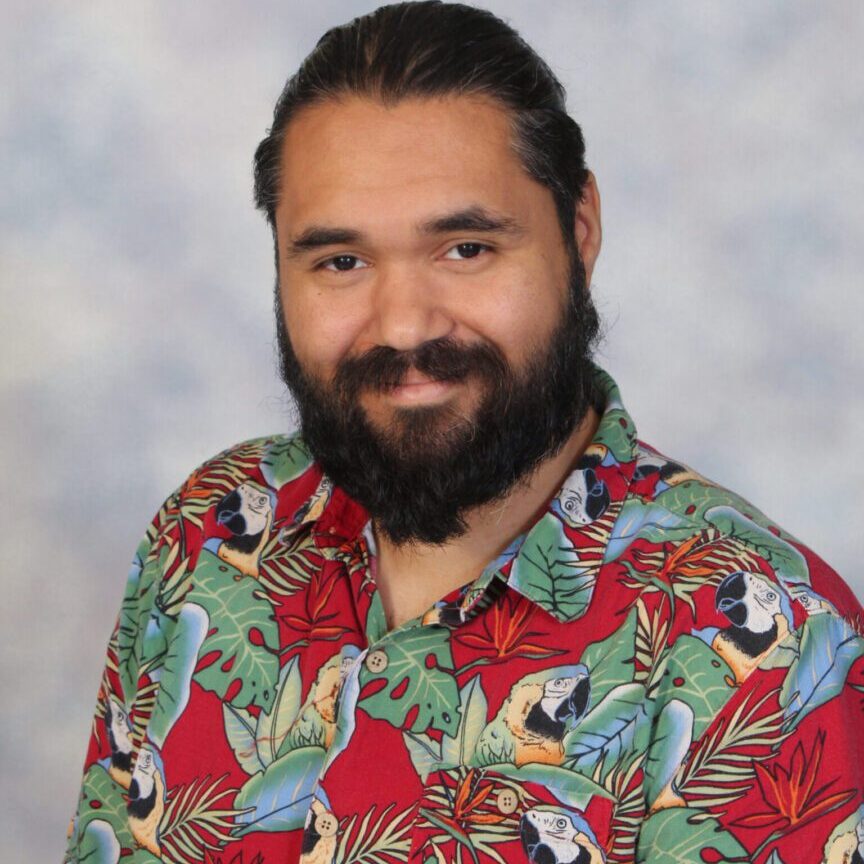 Man with beard wearing a tropical shirt.