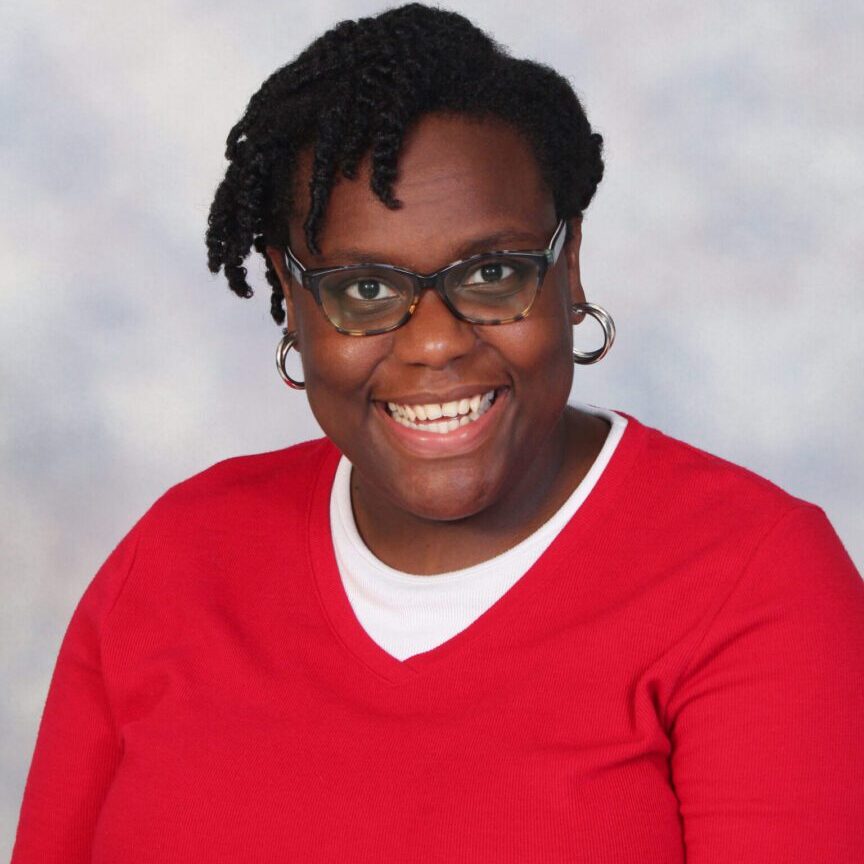 Smiling woman wearing glasses and red shirt.