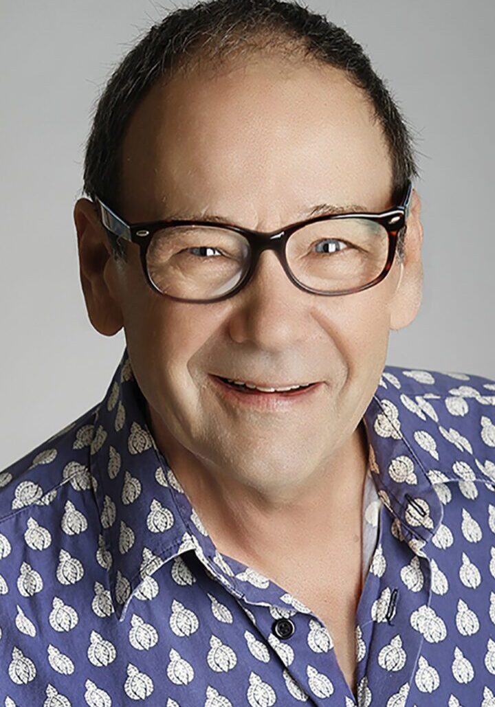 A man wearing glasses and a blue shirt serving on the board of directors.