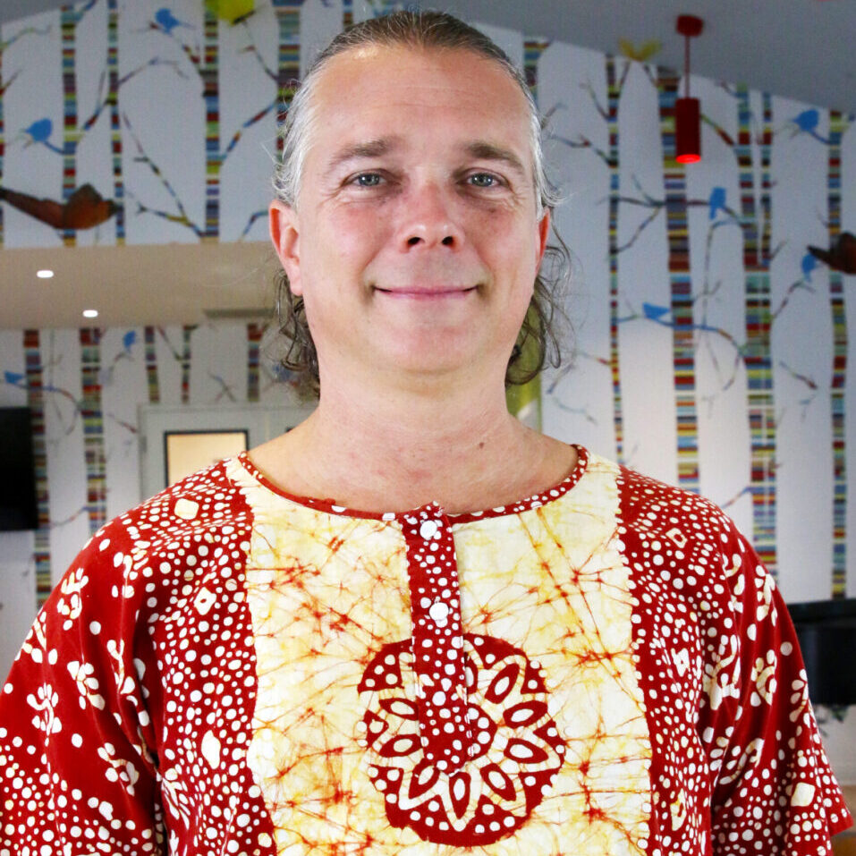 A teaching artist wearing a red and white shirt.