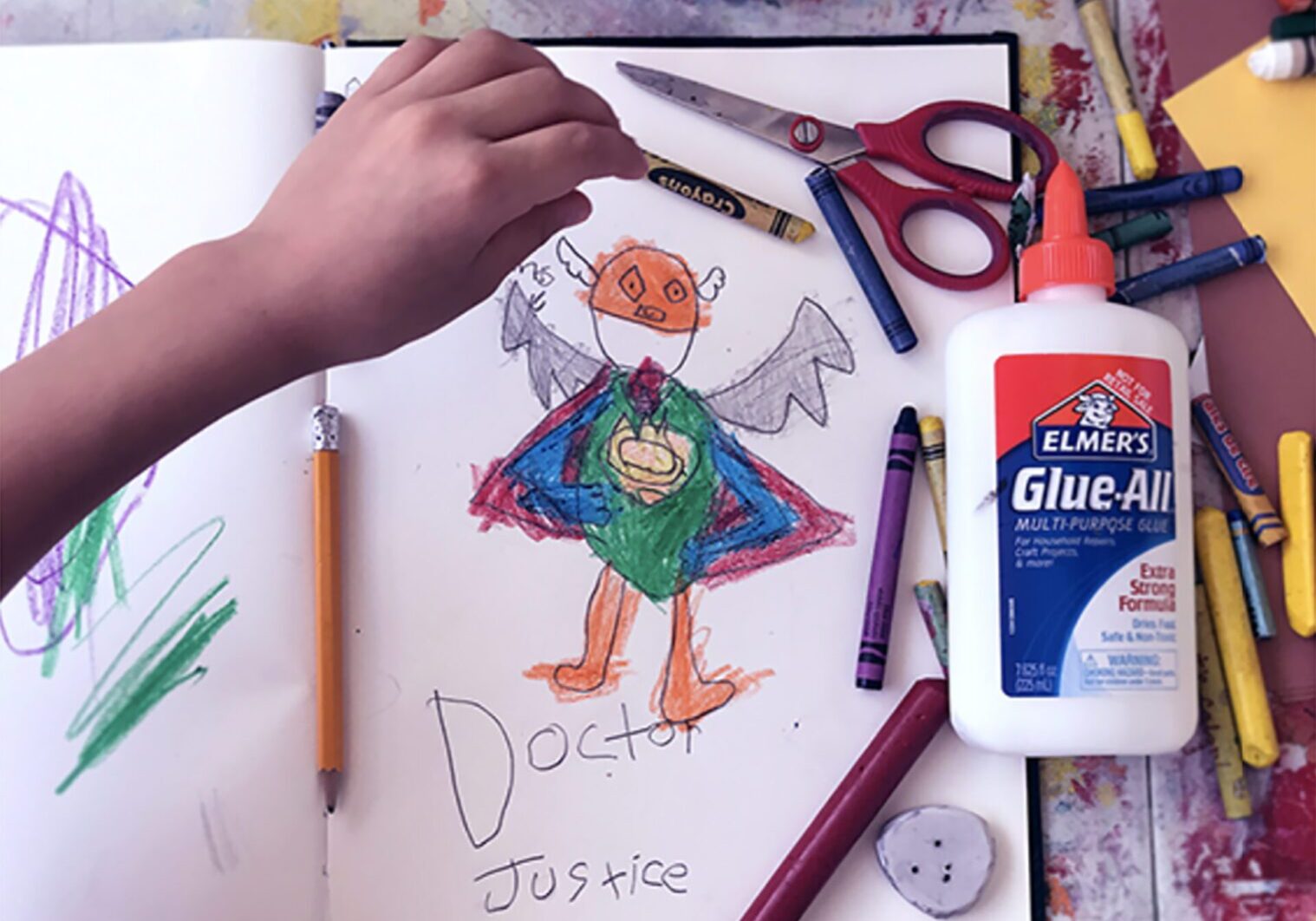 A child's drawing of a superhero using virtual creativity on a piece of paper.